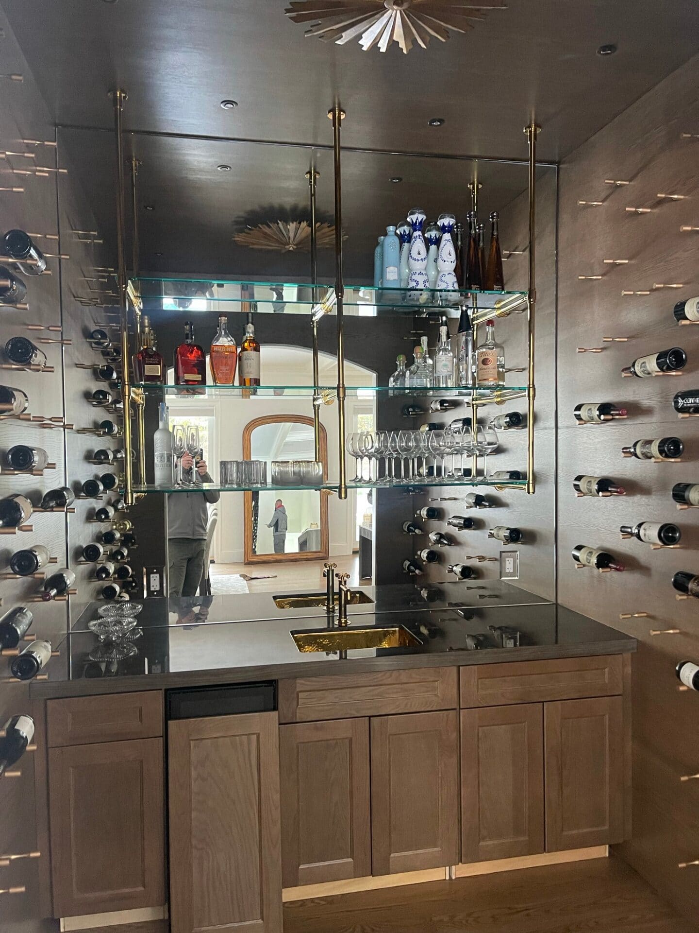 Custom luxury bar mirror wall installation with gold accent framing